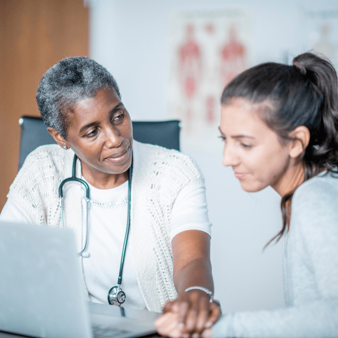 A doctor and a patient are looking at a laptop computer.