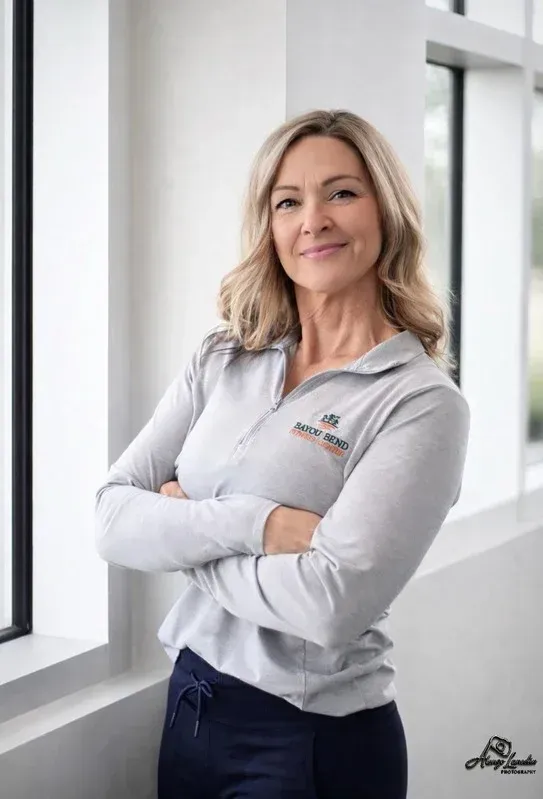 A woman is standing next to a machine in a gym.