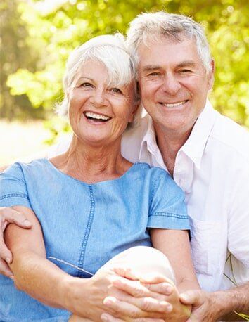 Senior couple sitting on grass together — General Dentistry in Tallahassee, FL