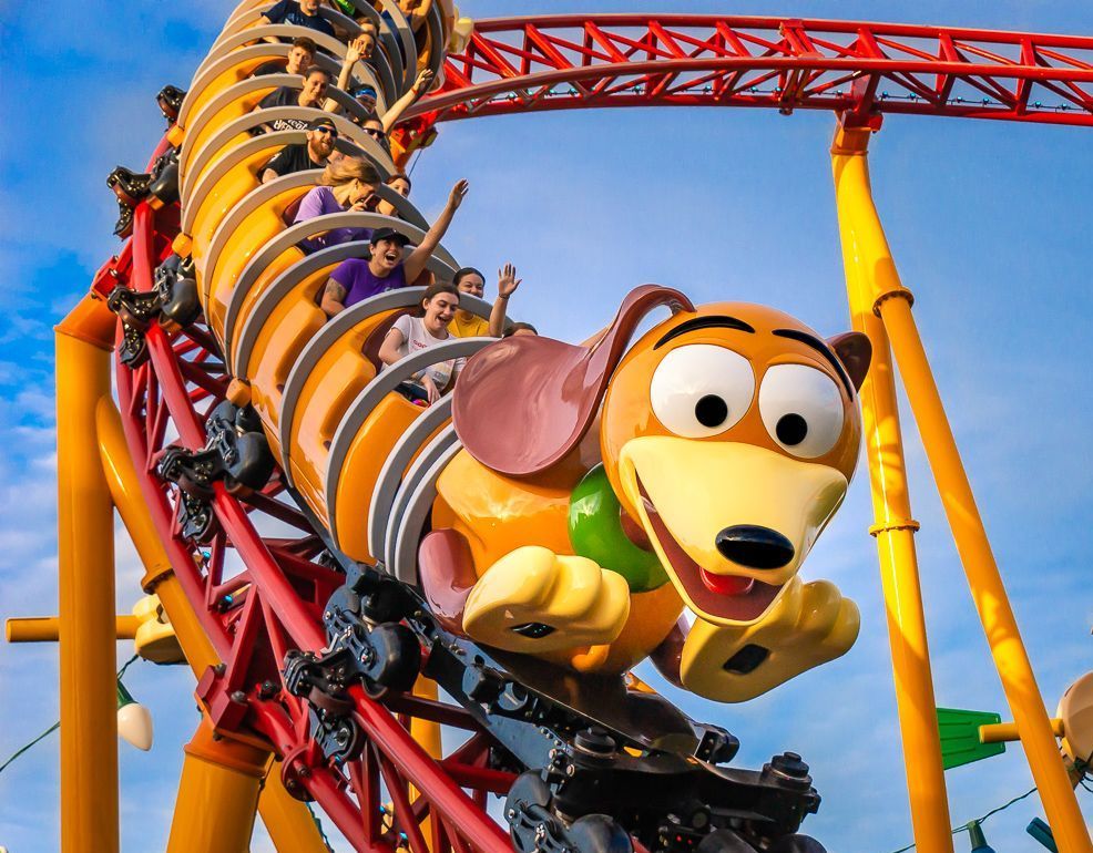 a group of people are riding a roller coaster with slinky dog .