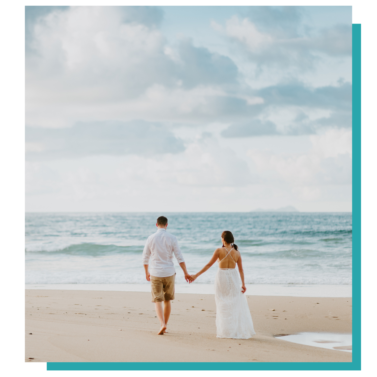 a man and a woman are walking on the beach holding hands .
