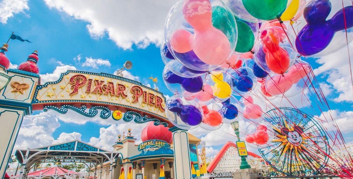 a large swimming pool surrounded by palm trees and umbrellas next to the ocean .