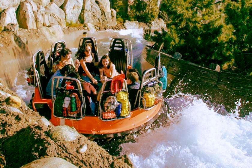 a man and two children are floating on tubes in a pool .