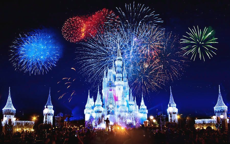 a castle is lit up with fireworks in the sky above it .