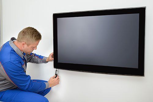 TV repair technician servicing flat-screen