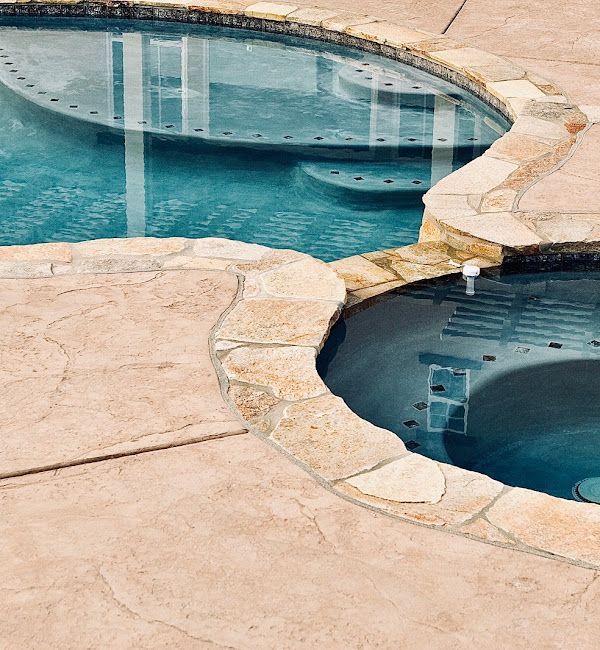 A swimming pool with a hot tub in the middle
