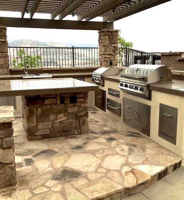 An outdoor kitchen with a grill and a table