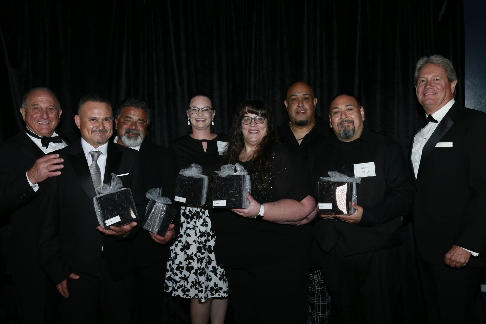 a group of people standing next to each other holding awards .