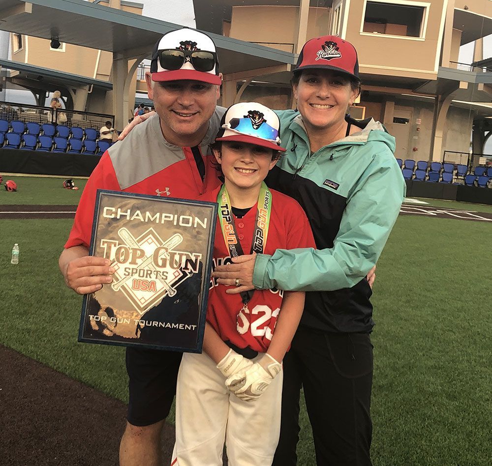 A family posing for a picture on a baseball field