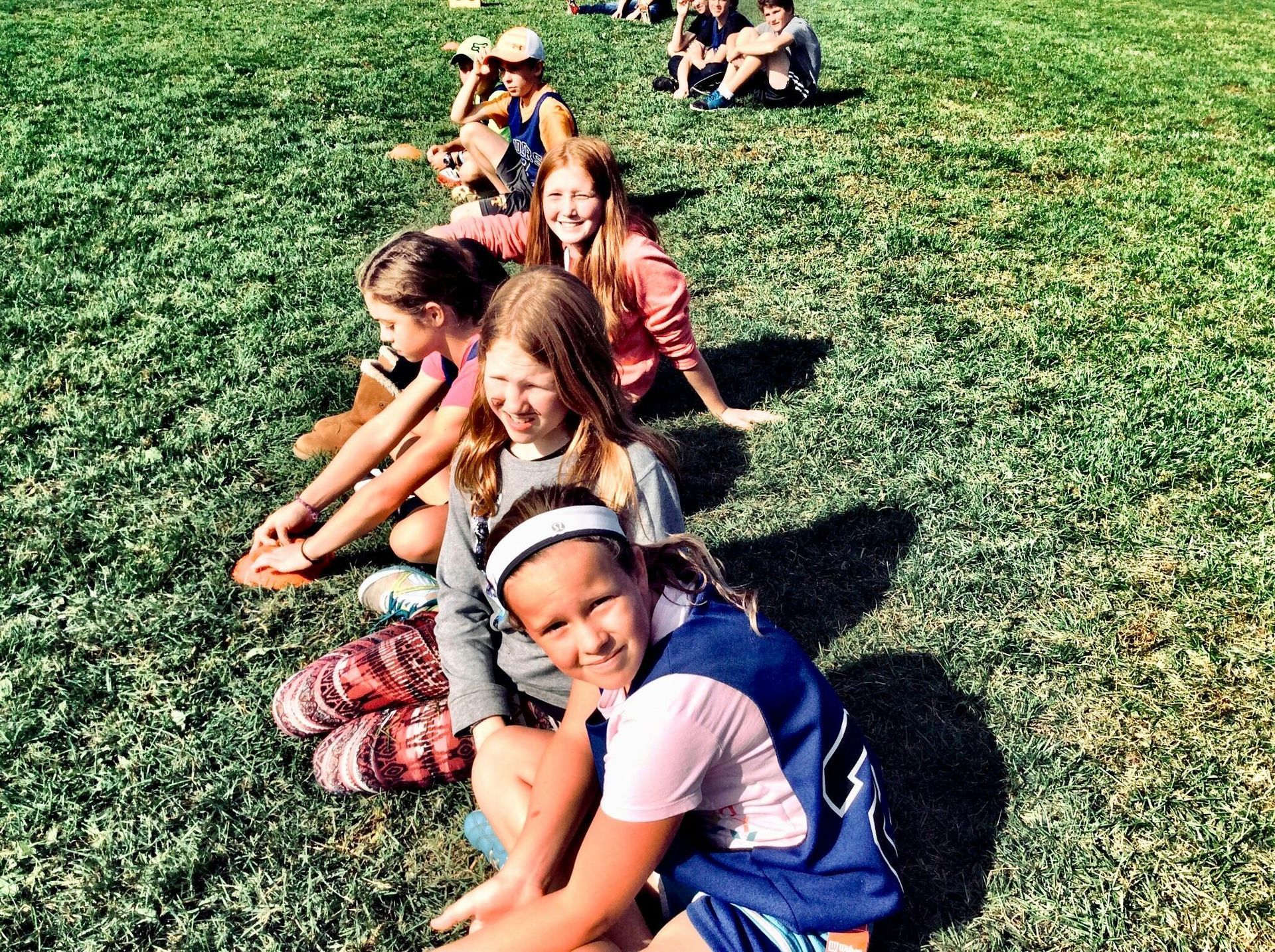 a group of girls sitting in grass