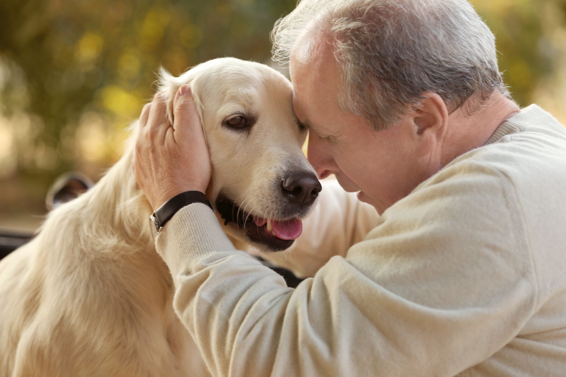 A man is petting a dog on the head.