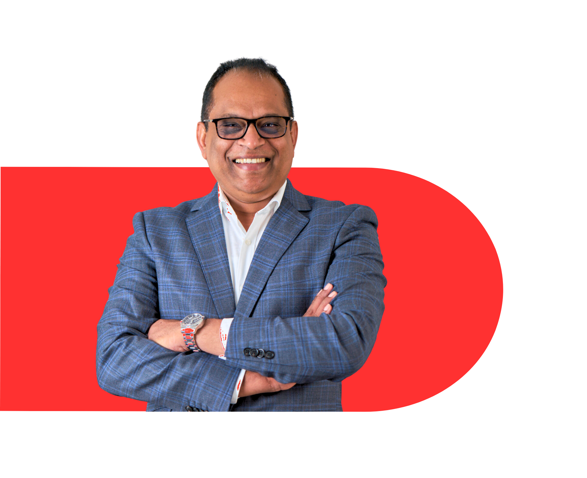 A man in a suit and glasses is standing with his arms crossed and smiling.