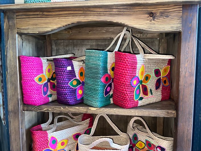 A wooden shelf with a bunch of colorful baskets on it.