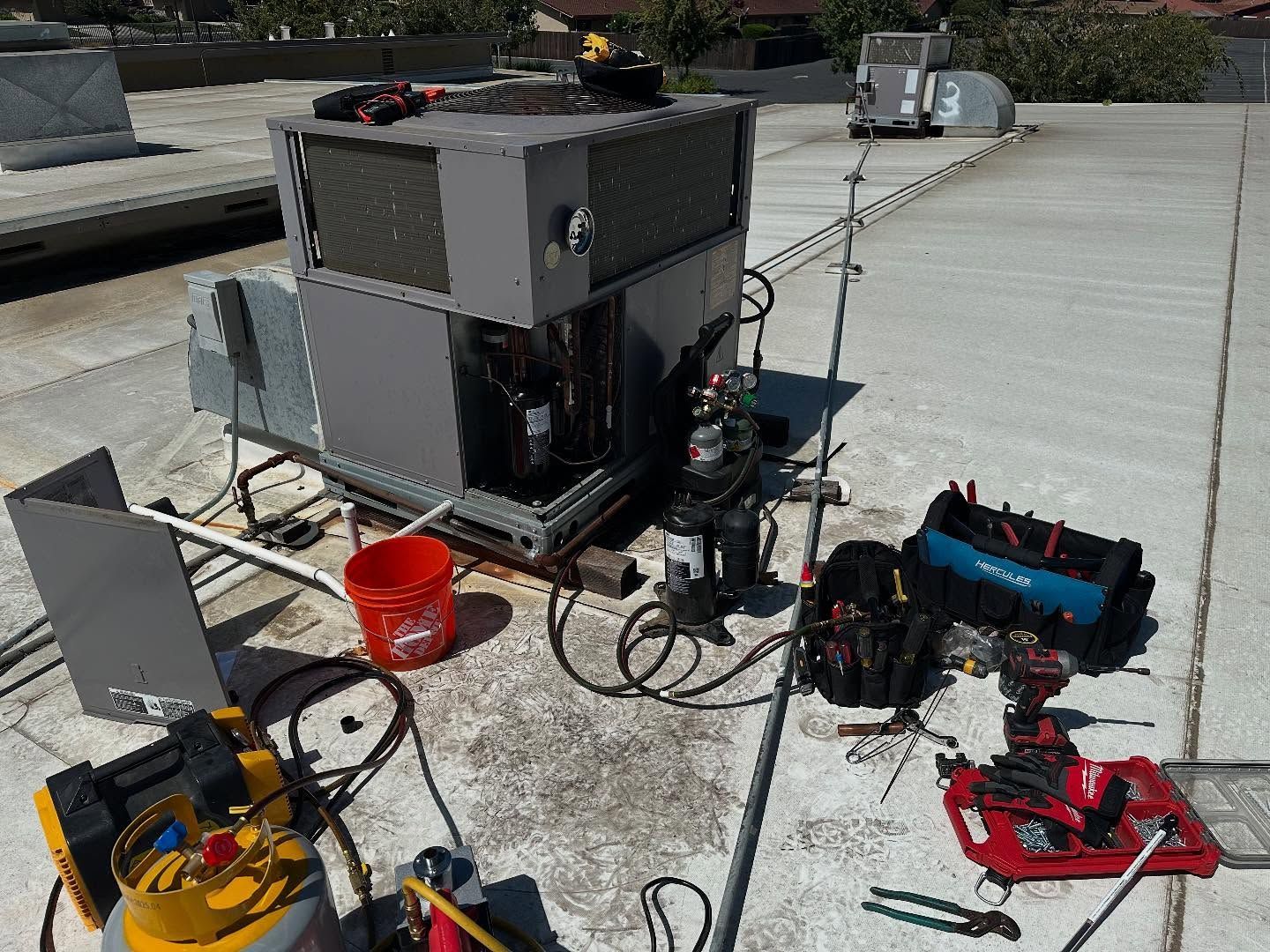 Outdoor equipment setup on a rooftop, with cables, tools, and a large gray machine.