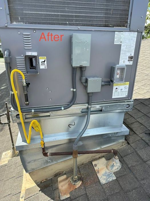 Electrical service panel outdoors with gray conduit and yellow marked cable on a brick base near pavement