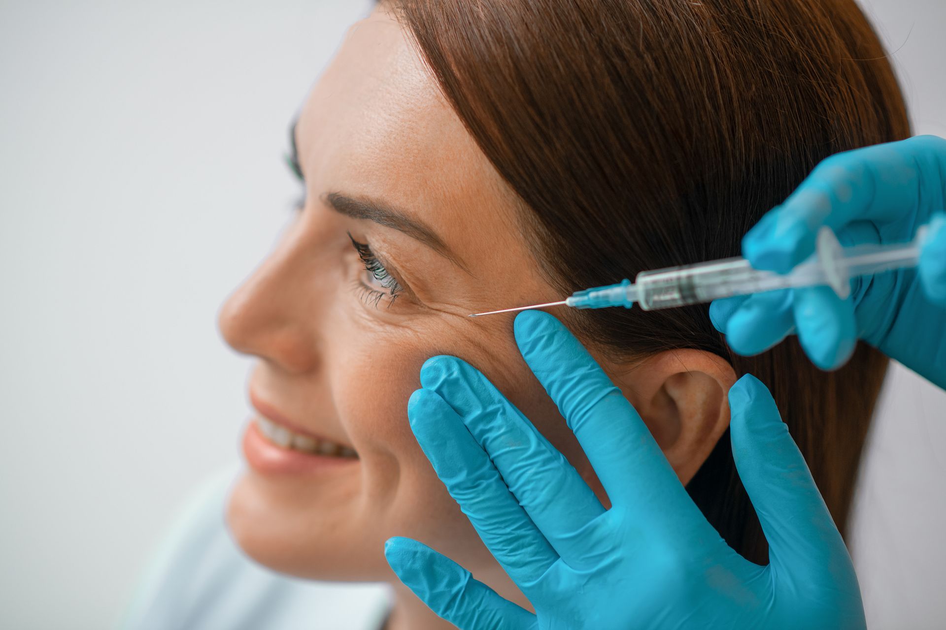 A woman is getting an injection near her eye.