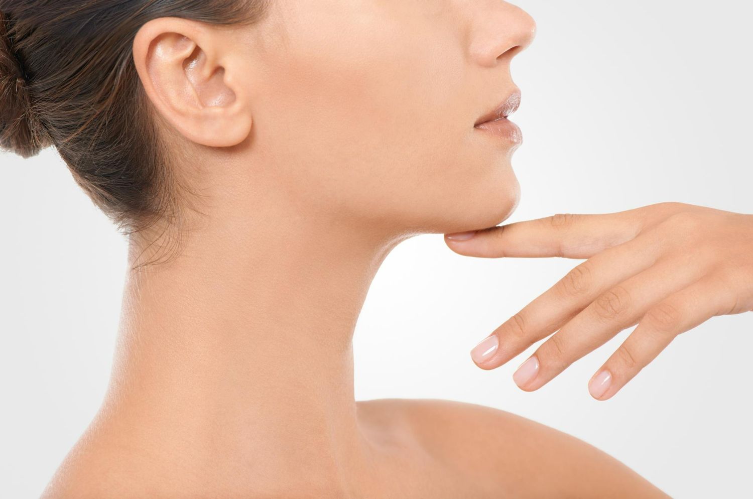 Profile view of a person with hand touching chin, neck and shoulder visible.