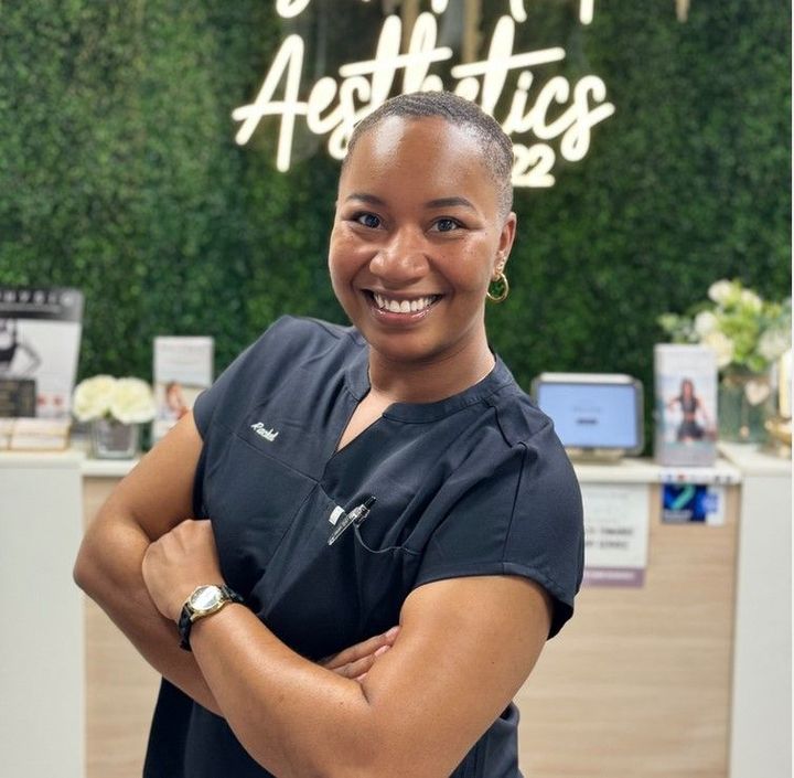 A woman standing in front of a sign that says aesthetics