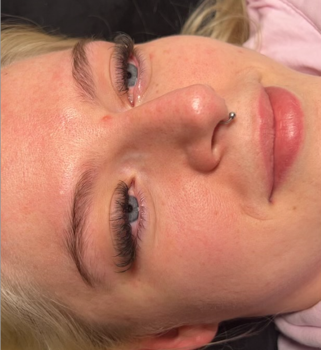 A close up of a woman 's face with a nose ring.