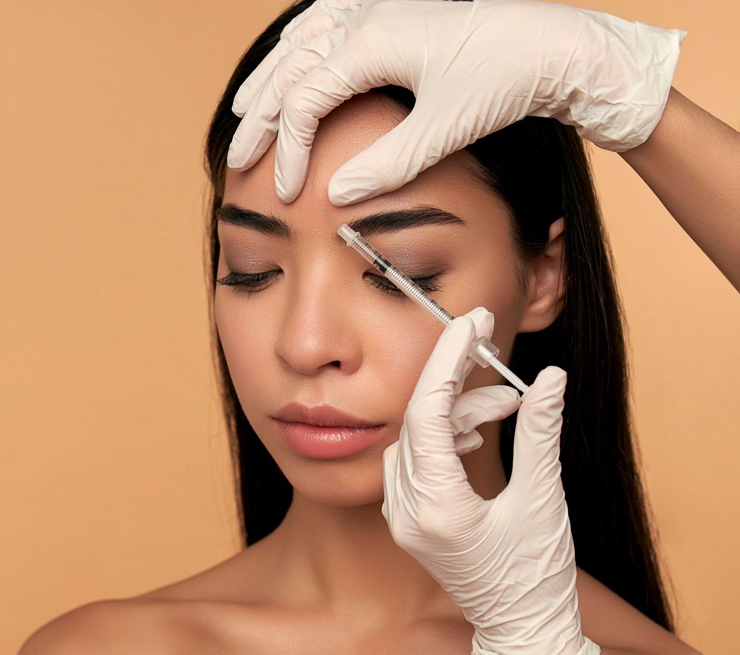 A woman is getting a botox injection in her face.