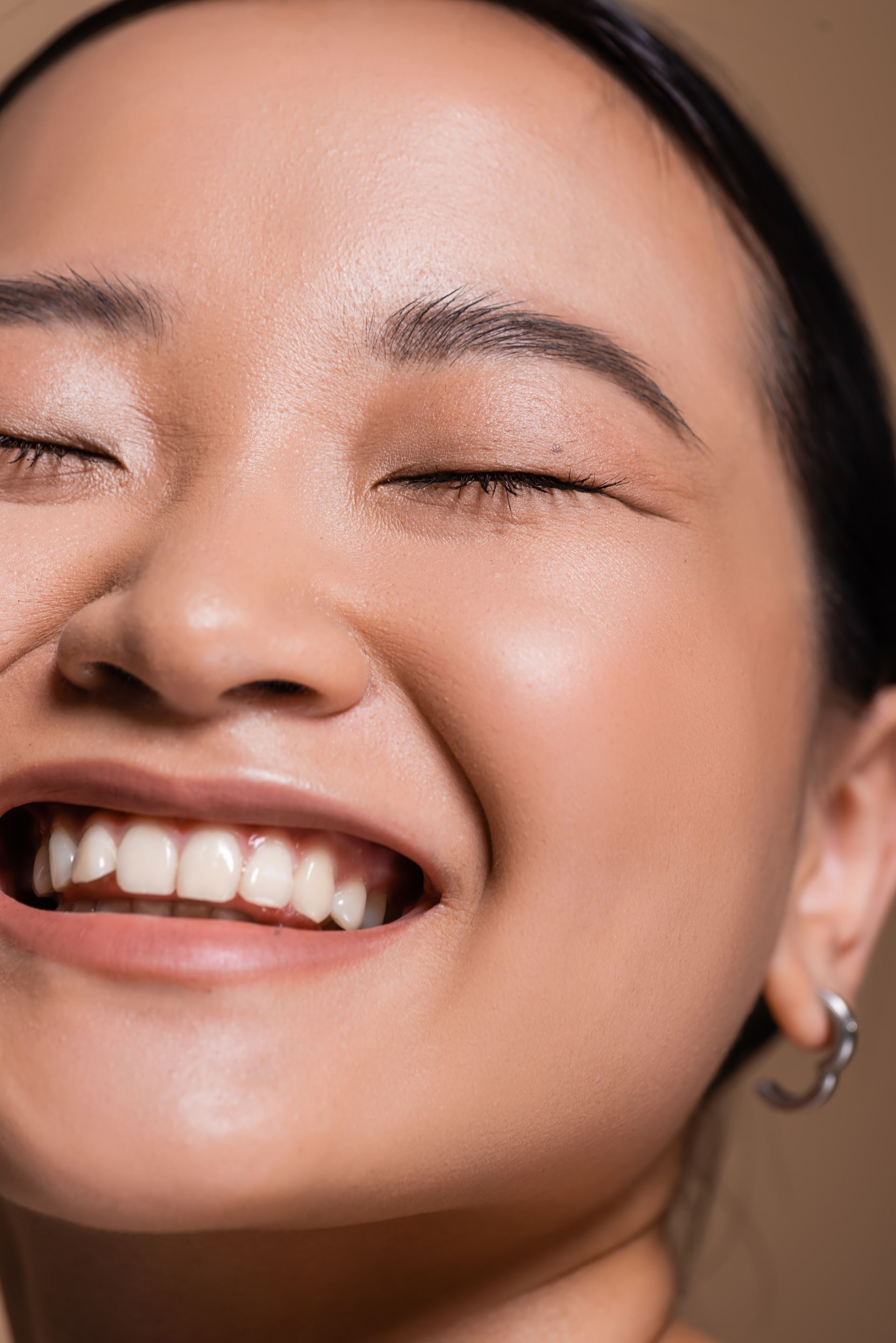 A close up of a woman 's face with her eyes closed and smiling.