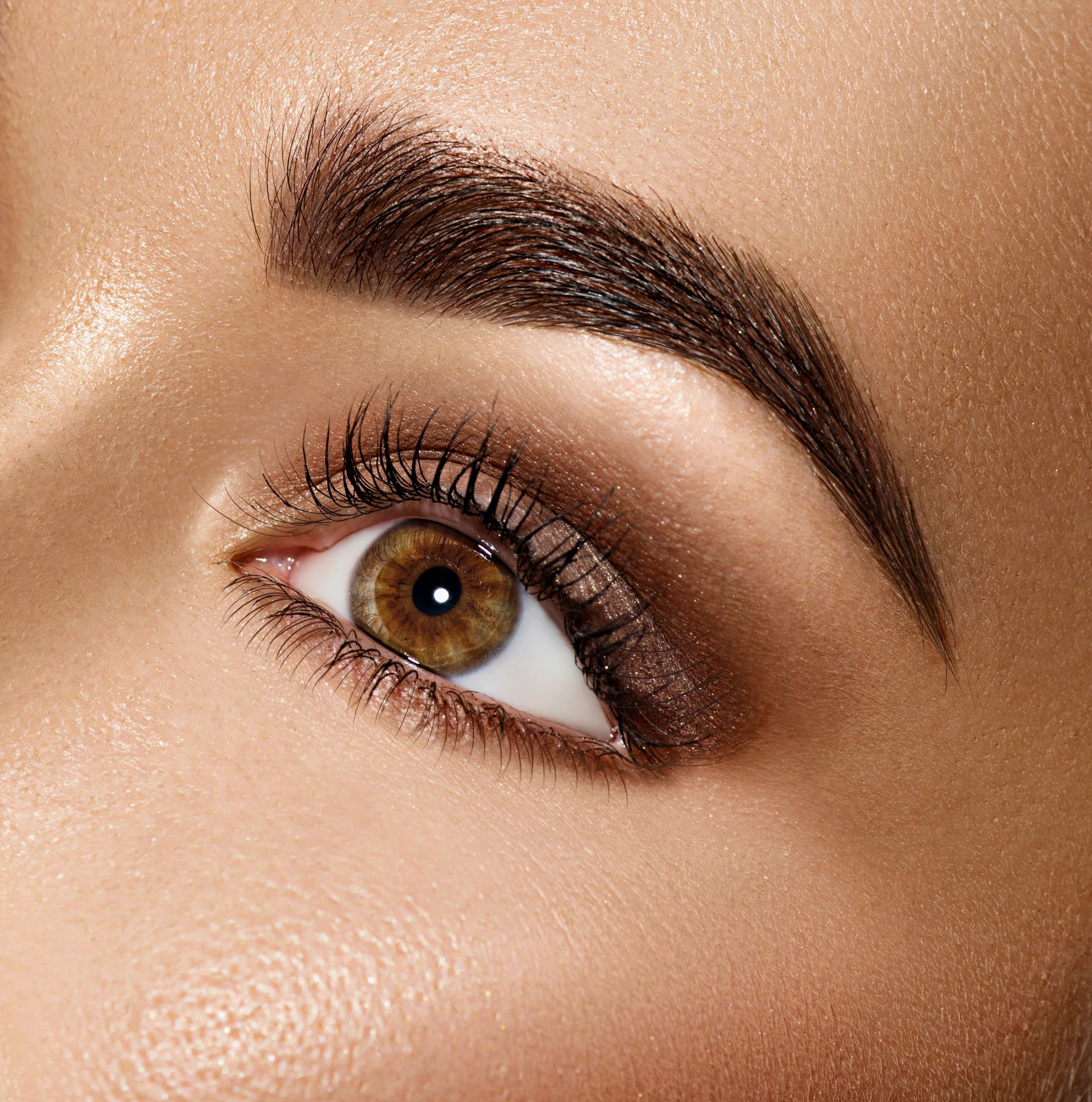 A close up of a woman 's eye with brown eyeshadow.