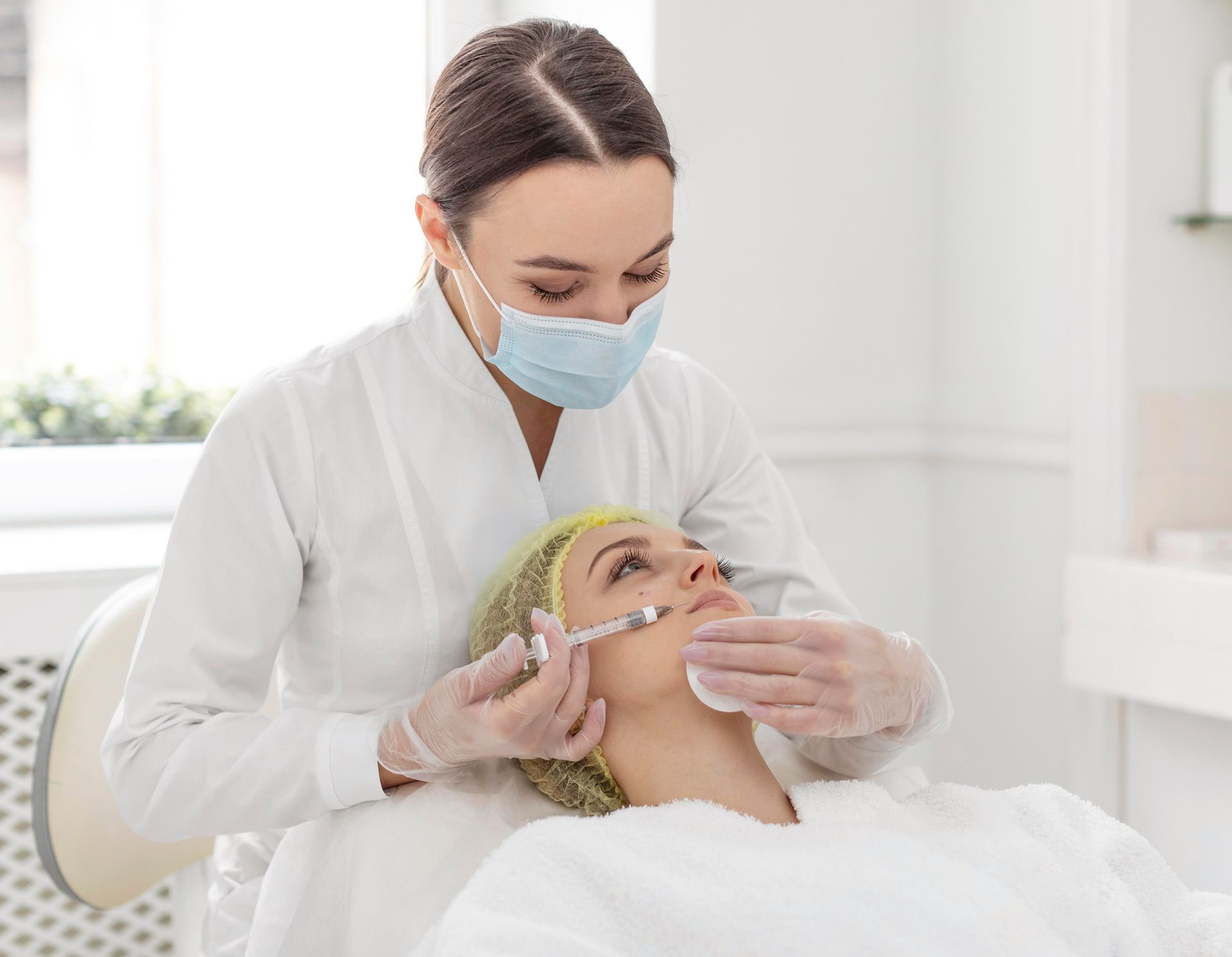 A woman is getting an injection in her face at a beauty salon.