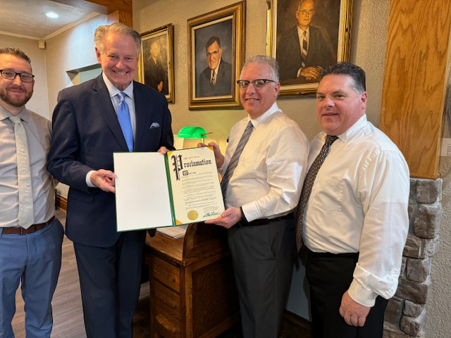 A group of men are standing next to each other holding a certificate