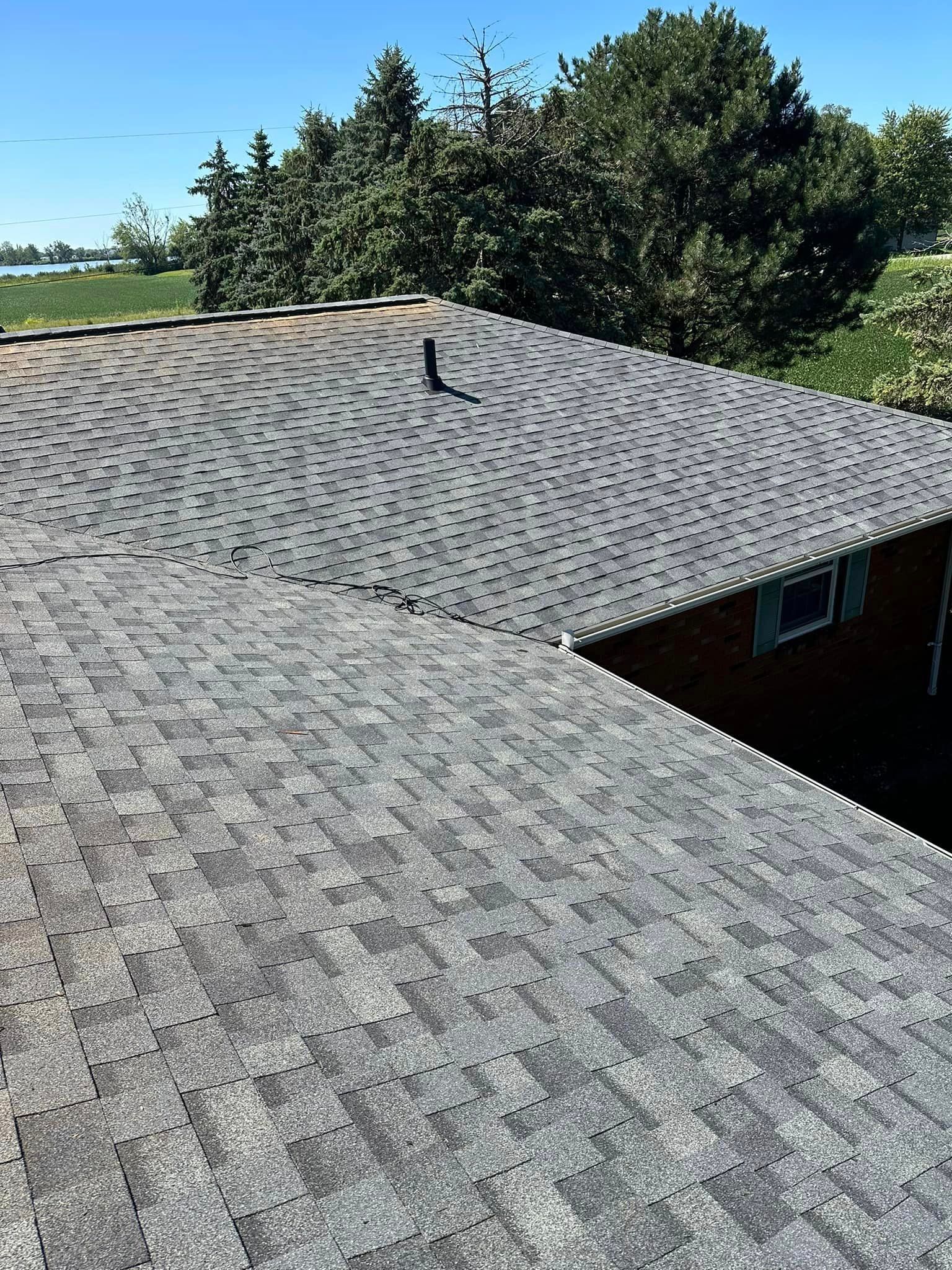 A Close Up Of A Roof Of A House With Trees In The Background - Sandusky, OH - Petrick Roofing and Remodel LLC