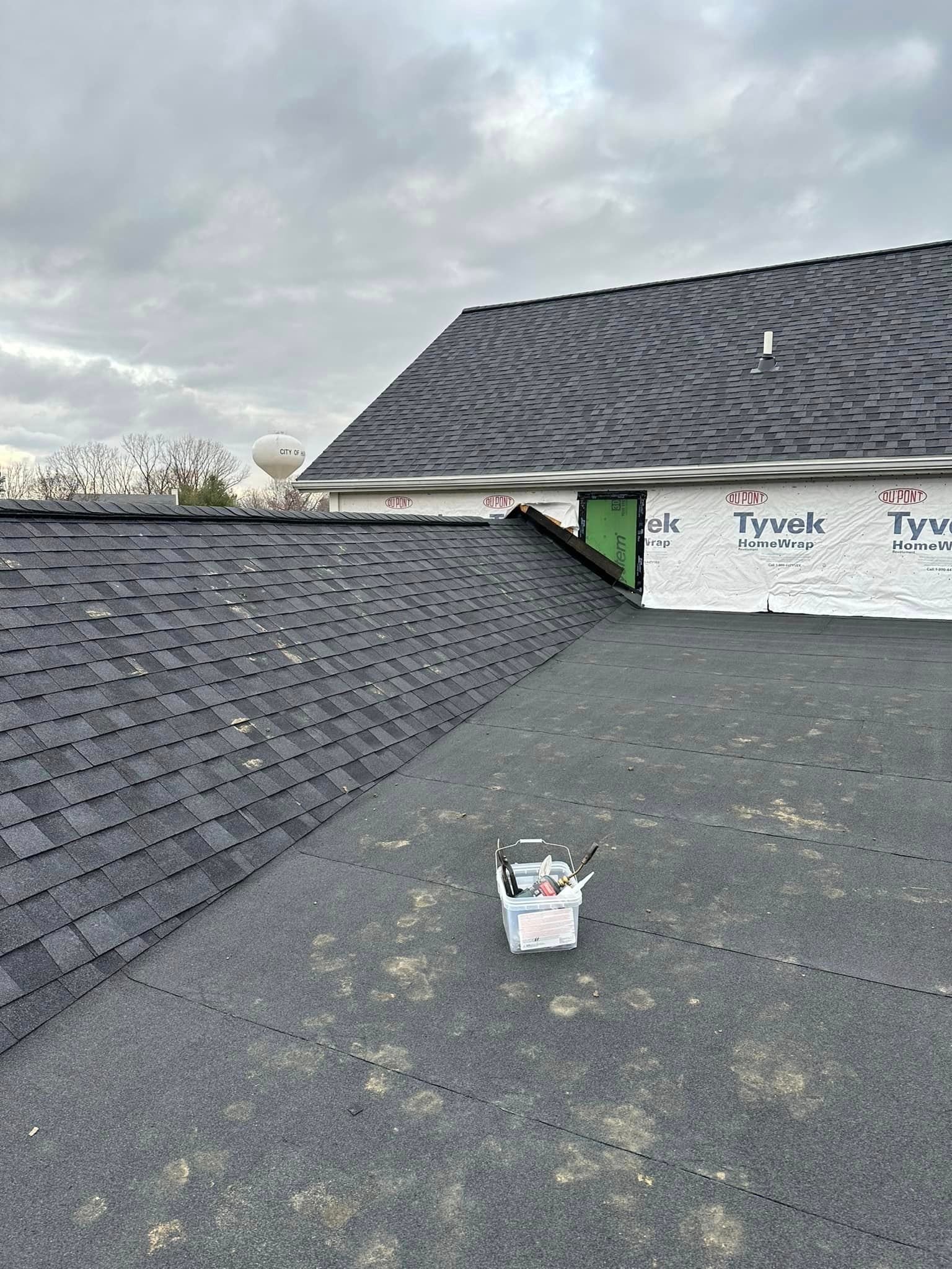 A Bucket Of Paint Is Sitting On The Roof Of A House - Sandusky, OH - Petrick Roofing and Remodel LLC
