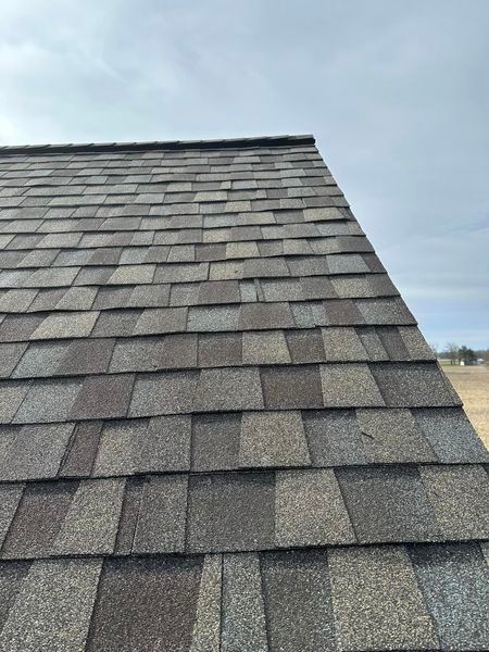 A Close Up Of A Roof With Shingles Against A Cloudy Sky - Sandusky, OH - Petrick Roofing and Remodel LLC
