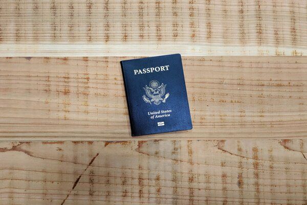 A passport is sitting on a wooden table.