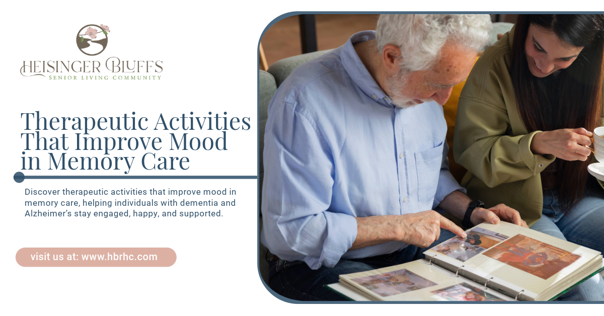 An elderly man and a memory care volunteer are looking at a photo album.