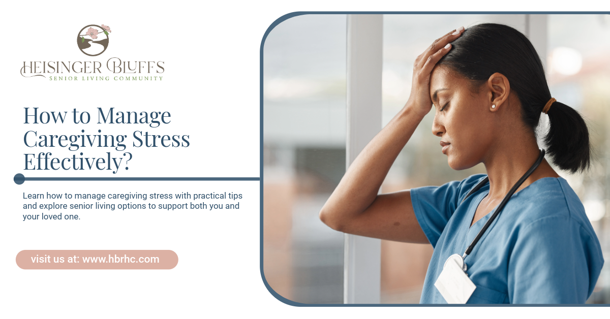 A caregiver in blue scrubs stressed, hand on forehead, by the window.