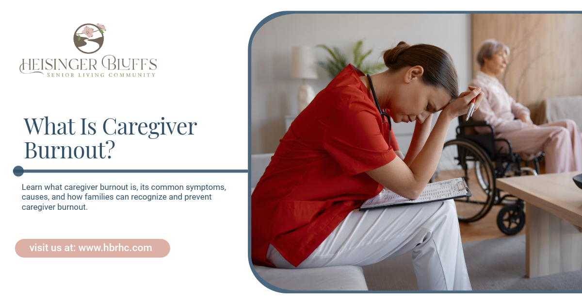 A caregiver with her head in her hands, looking exhausted, sits near an elderly person in a wheelcha