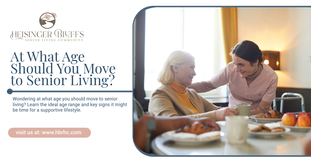 A caregiver is helping an elderly woman sit at a table.