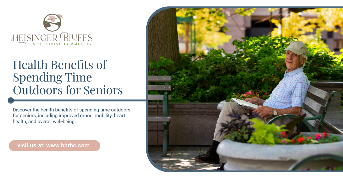 Older man reading outdoors, surrounded by greenery. 