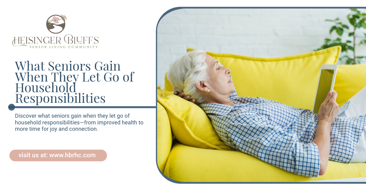 An elderly woman is laying on a yellow couch reading a book.