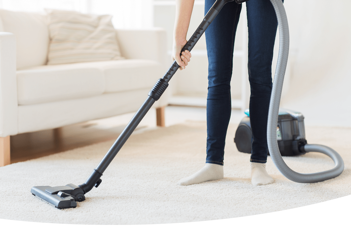 A person vacuuming the floor in a living room 