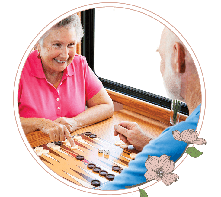 An elderly man and woman playing a game of backgammon