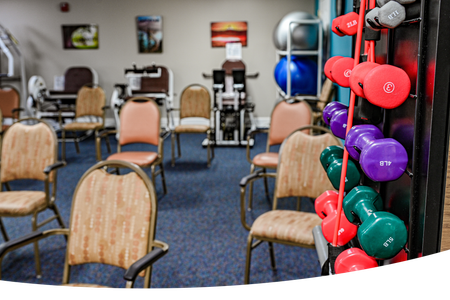 A room with chairs and dumbbells 