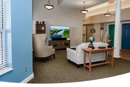 A living room with a couch, table, chairs. and a television set