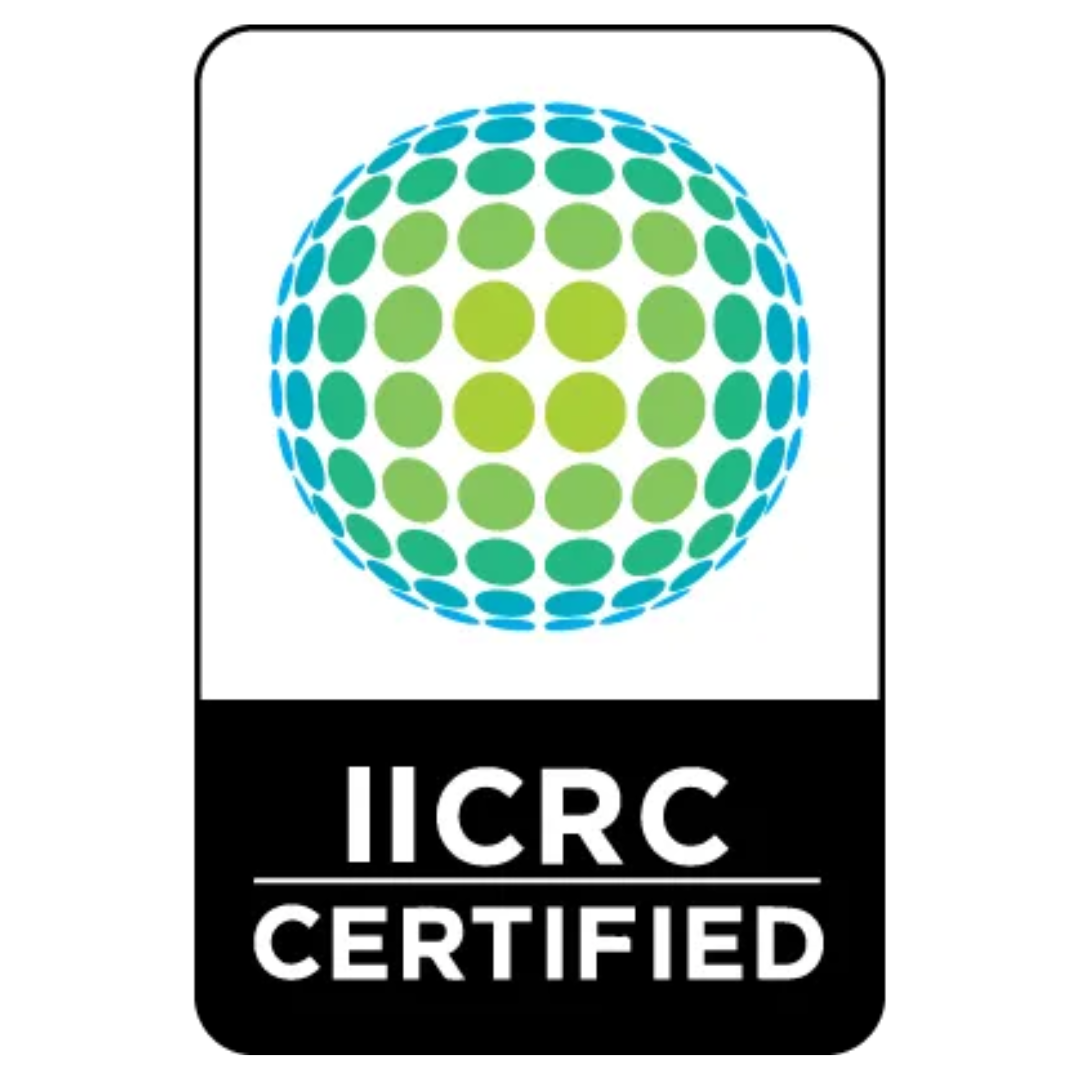 A dark blue key box with a key inserted, mounted on a beige wall near a house.