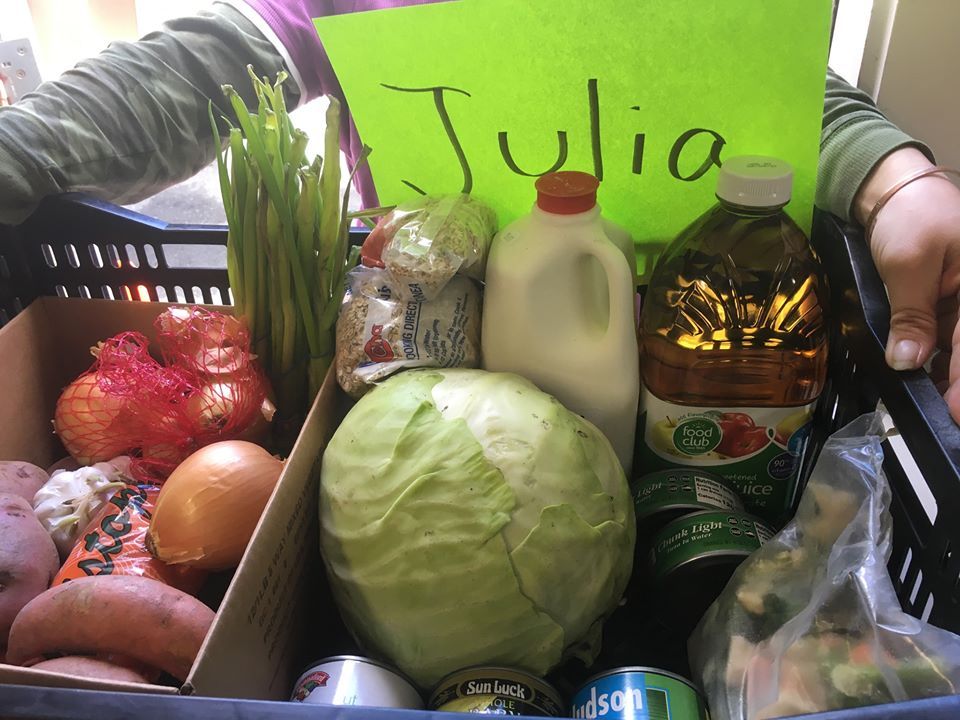 A person is holding a basket of food with a sign that says julia on it.