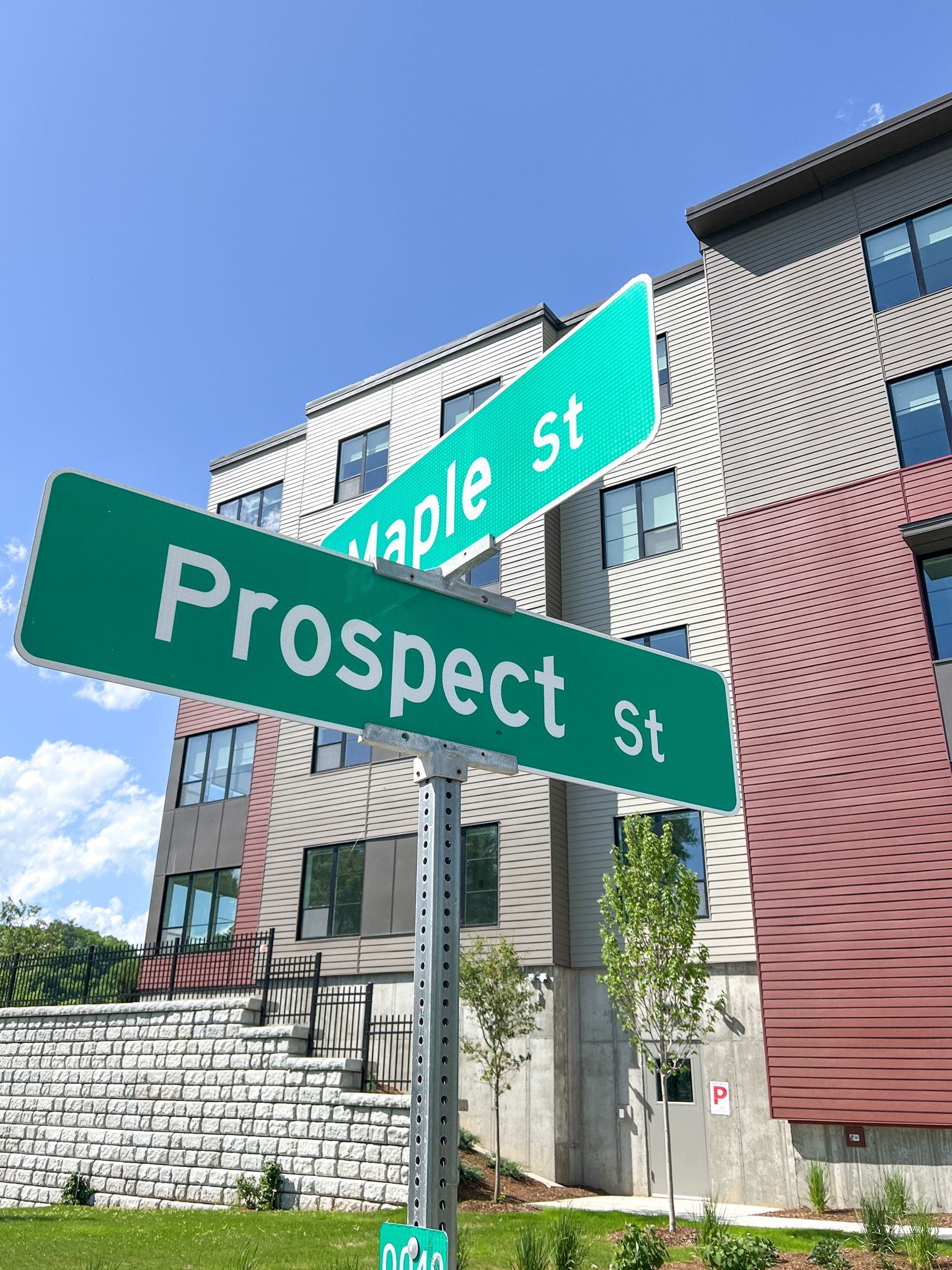 A green street sign for prospect st. in front of a building