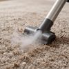 Beige textured rug on a floor, sunlight streaming in from a window.