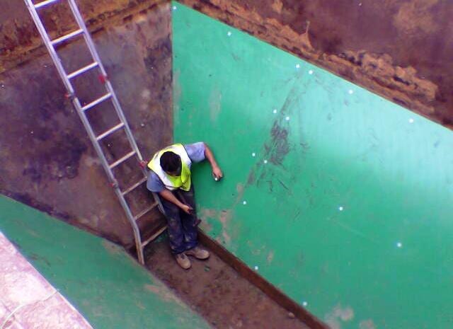 A man is standing next to a ladder in a green room - Engineering Tooling In Thornton, NSW