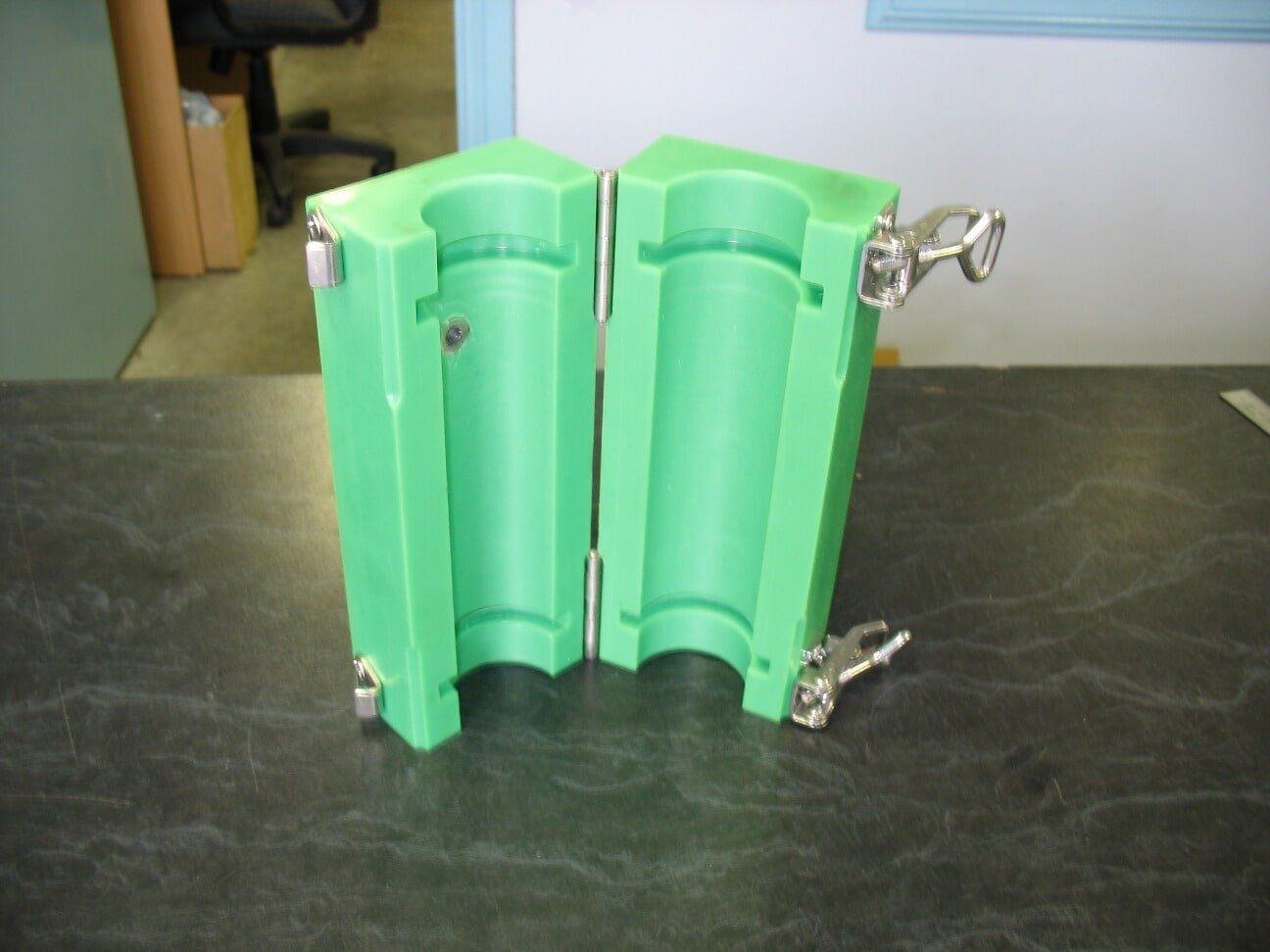 A green plastic mould is sitting on a table - Engineering Tooling In Thornton, NSW