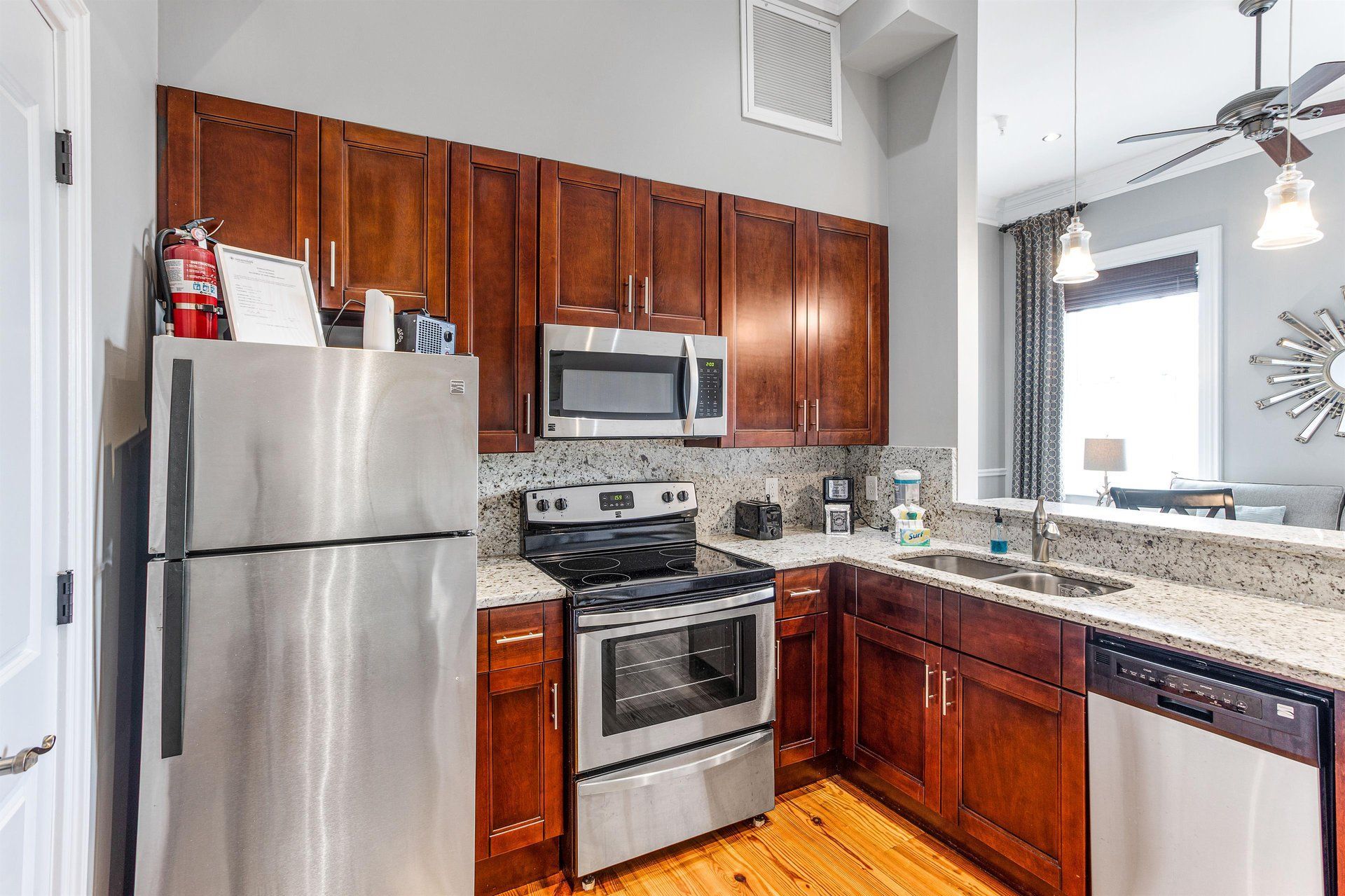 Kitchen with stainless steel appliances, dark wood cabinets, granite countertops, and hardwood floors.