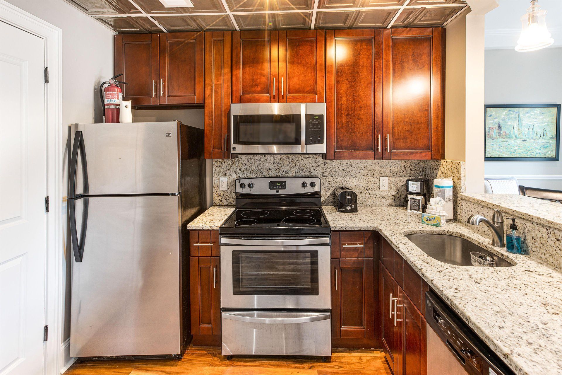 Kitchen with stainless steel appliances, dark wood cabinets, and granite countertops.
